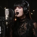 MAPHRA singing in a dark studio during her “Doomed” vocal cover performance