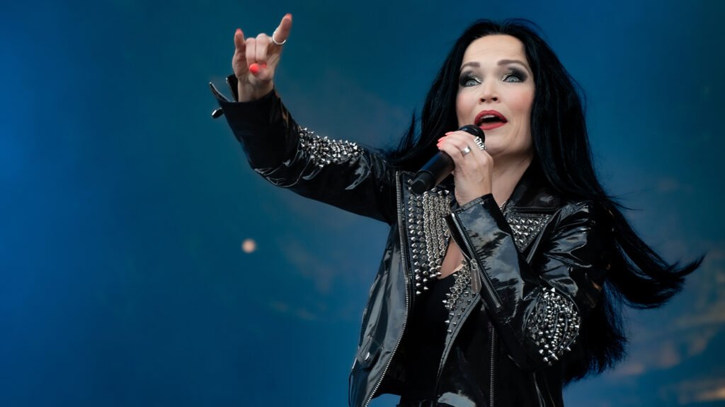 Featured image for an article about the 15 best female-fronted rock and metal covers of all time, featuring Tarja Turunen on stage